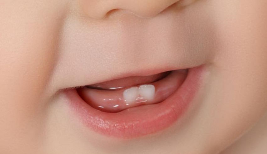 A close up of a baby's mouth with teeth.