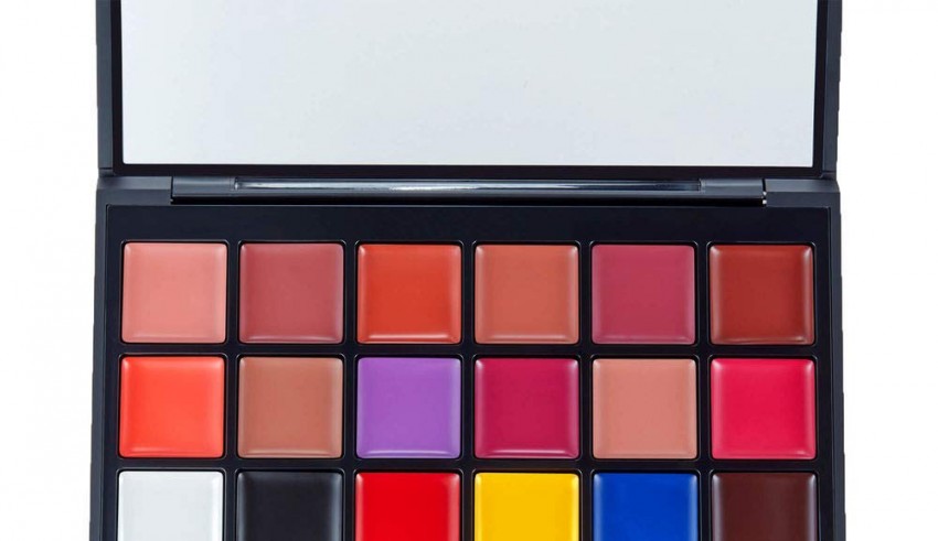 A makeup palette with different colors and a brush.