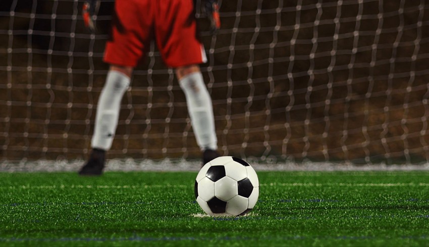 A soccer ball in front of a goal.