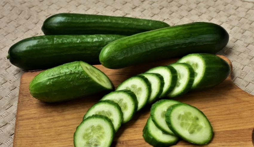 Sliced cucumbers on a wooden cutting board.