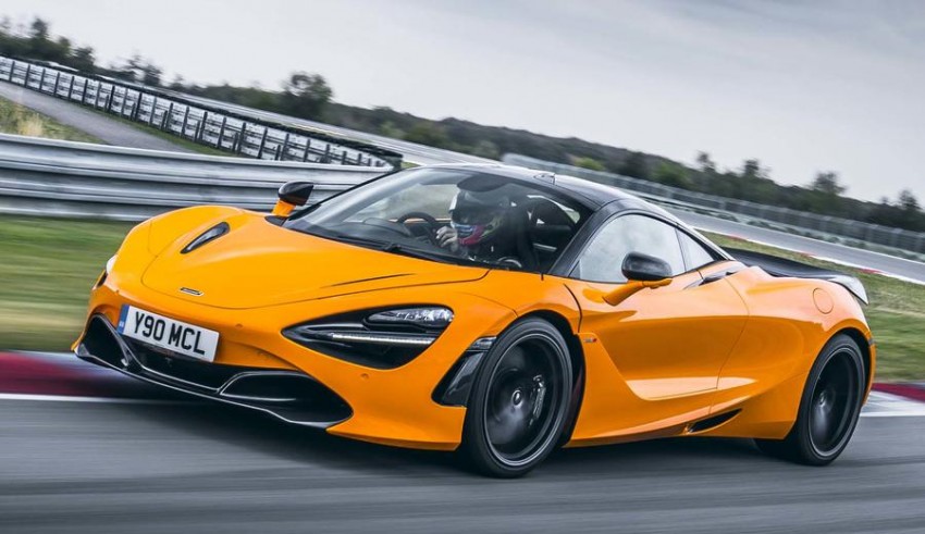 The orange mclaren 720s is driving on a track.