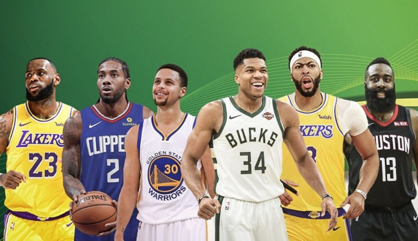 A group of basketball players standing in front of a green background.