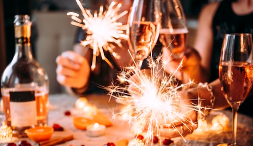 A group of people holding sparklers at a table.