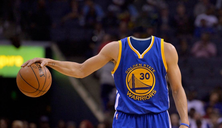 A golden state warriors player holding a basketball.