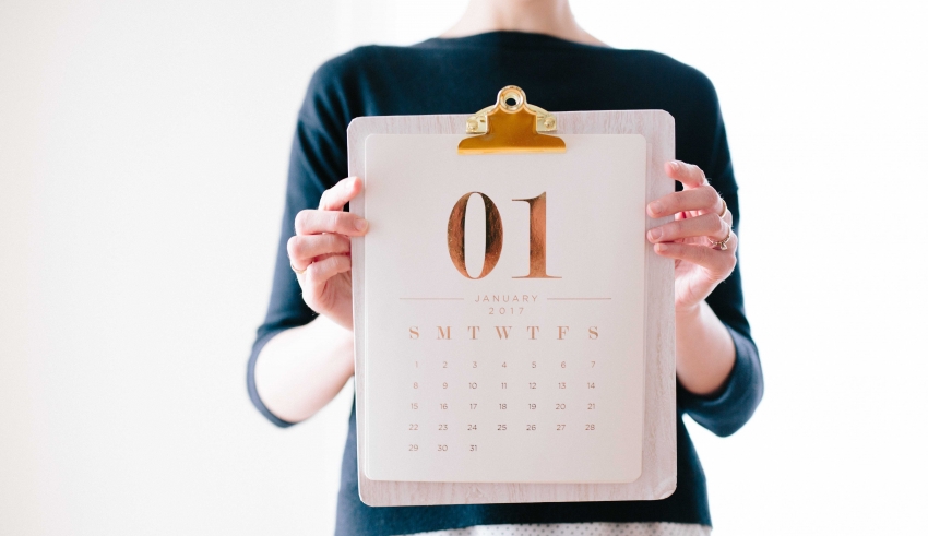 A woman holding a calendar with the number 10 on it.