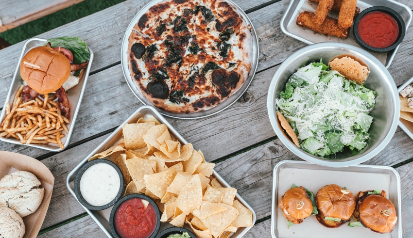 A picnic table with a variety of food on it.