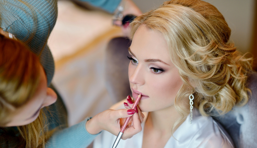 A woman is getting her makeup done by a makeup artist.