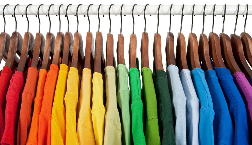 Colorful t - shirts on a hanger.