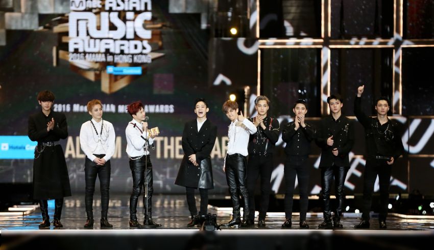 A group of k - pop boys standing on stage.