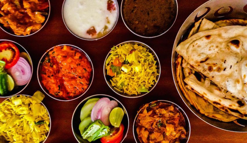A variety of indian food on a wooden table.