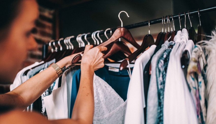 A woman is putting clothes on a hanger.