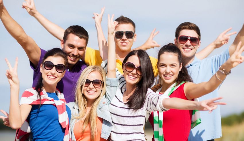 A group of friends posing for a photo on the beach.