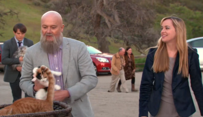 A man with a beard and a woman with a cat in a basket.
