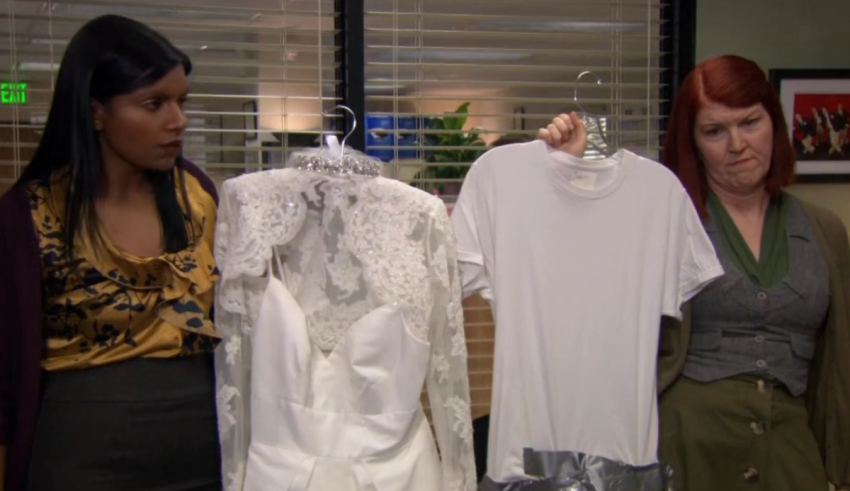 Three women are standing in front of a rack of t - shirts.