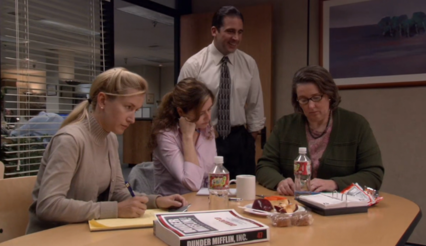 A group of people sitting around a table in an office.