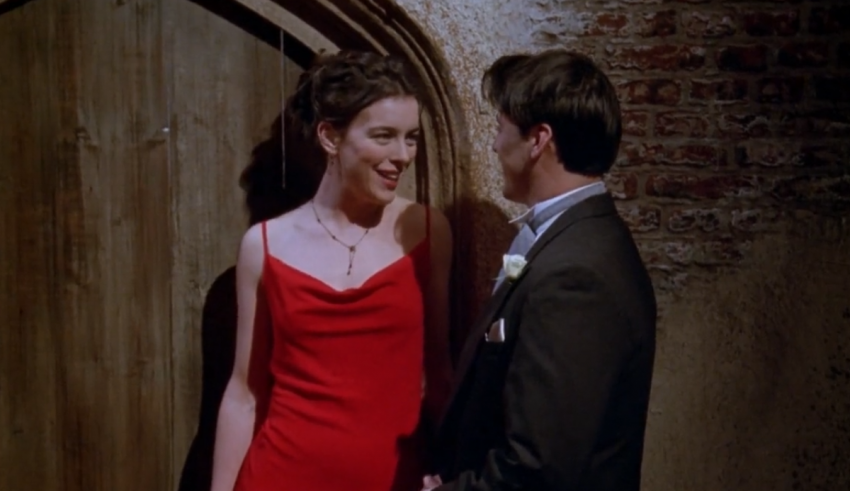 A man and woman in a red dress standing next to a door.