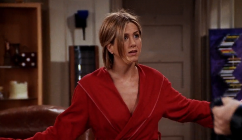 Jennifer aniston in a red robe in a living room.