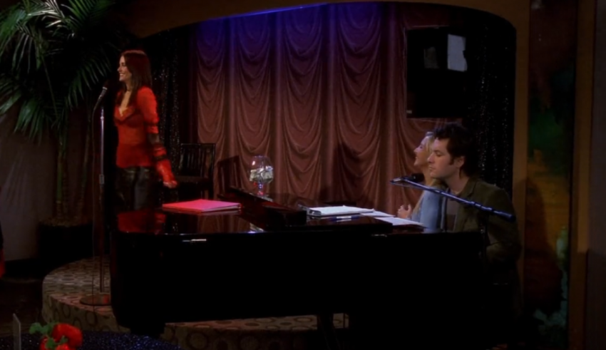 A man and woman sitting at a piano in a room.