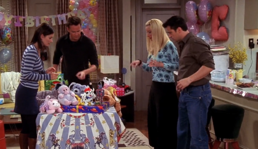 A group of people standing around a table with stuffed animals.