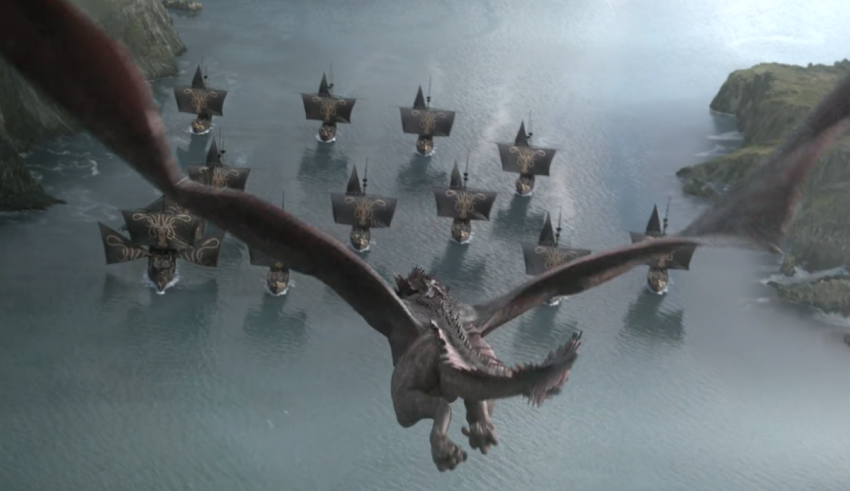 A large group of dragons flying over a body of water.