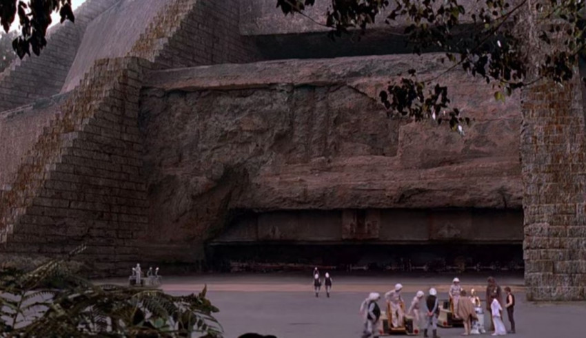 A group of people standing in front of a large stone building.