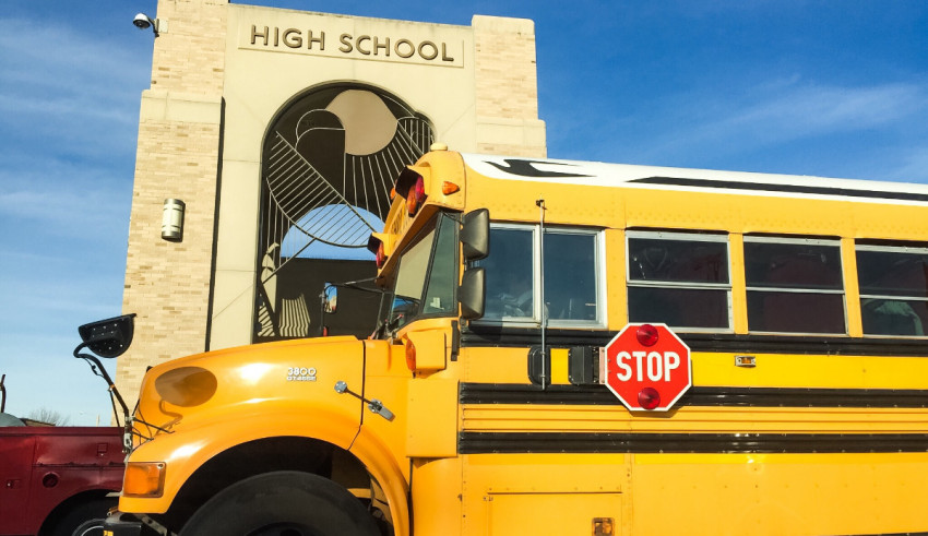 A yellow school bus parked in front of a building.