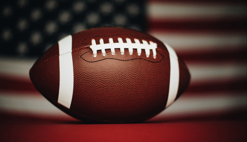 A football with an american flag in the background.