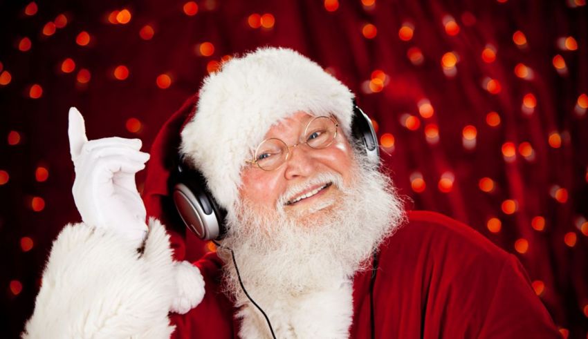 Santa claus wearing headphones and pointing to the camera.
