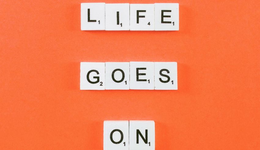 The word life goes on spelled out in scrabble letters on an orange background.