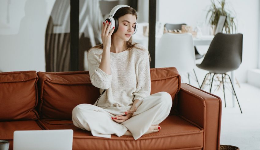 Young woman listening to music while sitting on a couch.