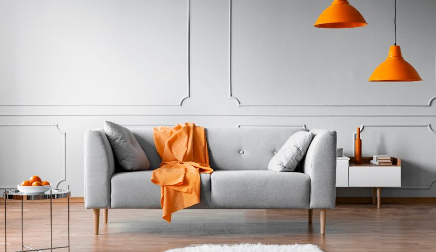 An orange couch in a room with white walls.