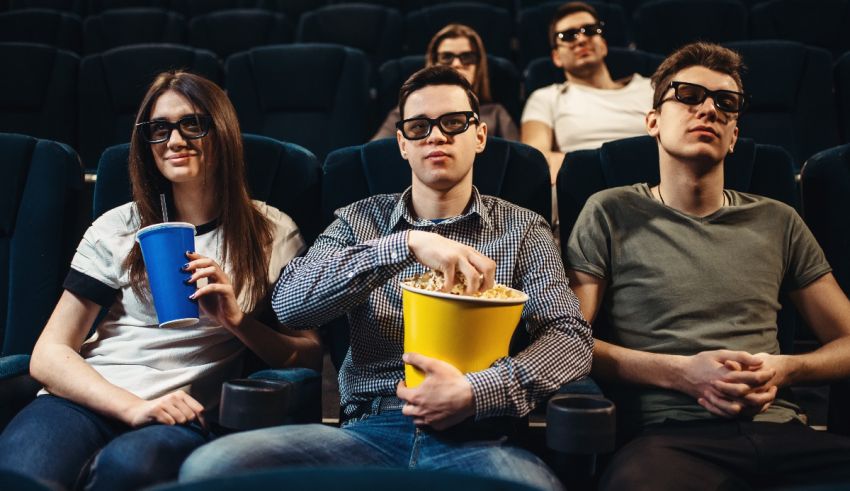A group of people sitting in a theater watching a movie.