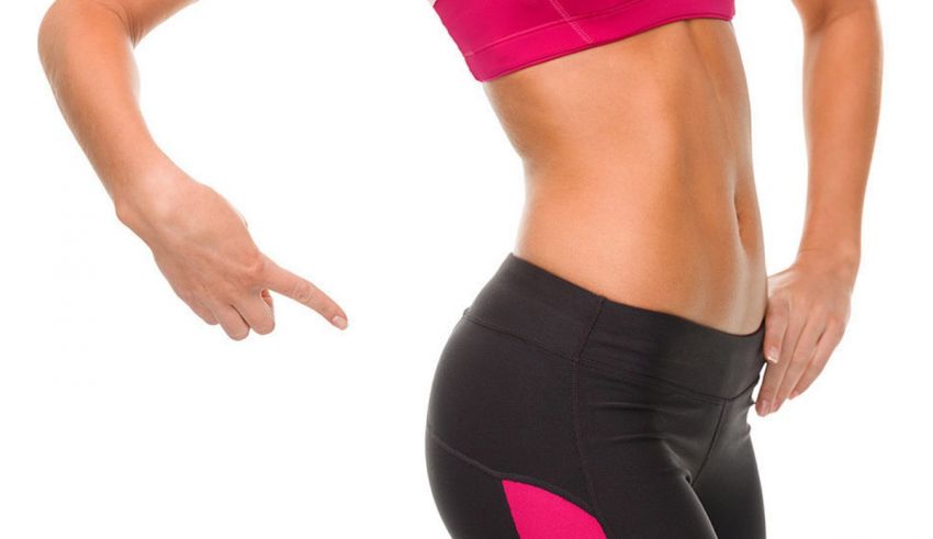 A woman is pointing to her stomach.
