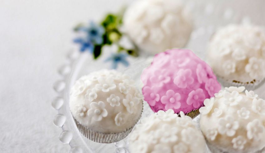 White and pink cupcakes on a clear plate.