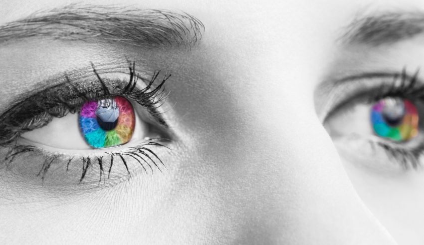 A close up of a woman's eyes with rainbow colored eyes.