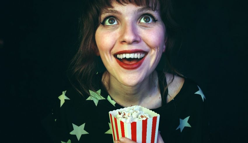 A woman holding a popcorn box with stars on it.