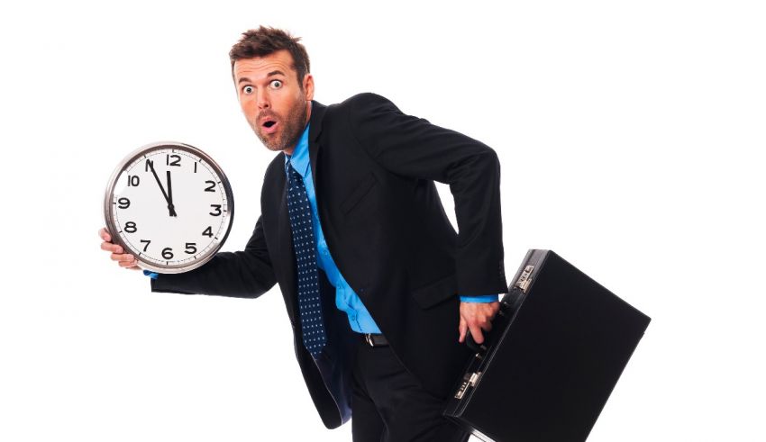 A businessman holding a clock and a briefcase.