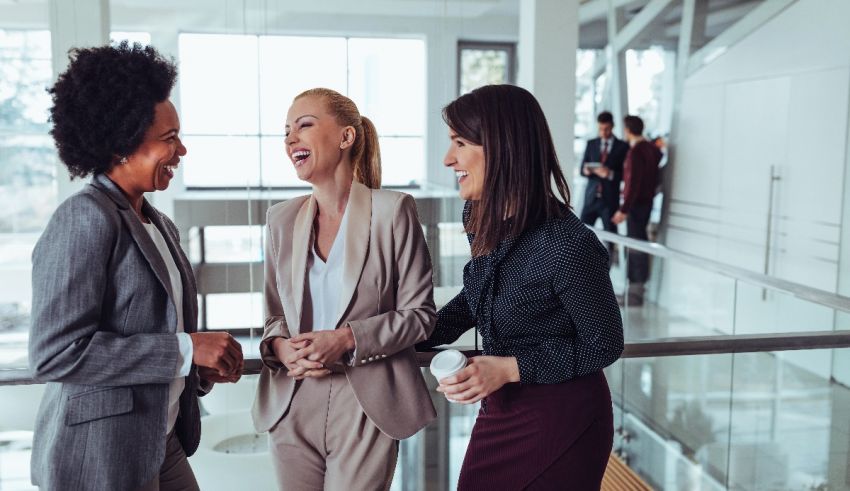 Three business women talking to each other in an office.