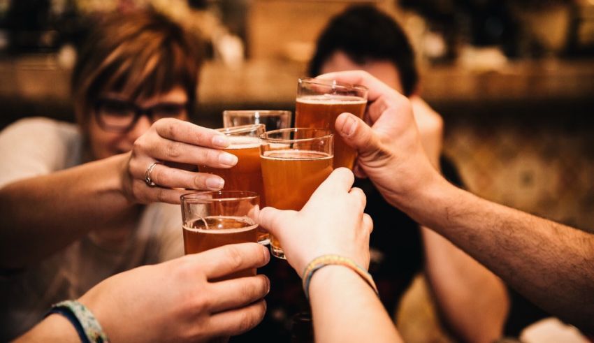 A group of people toasting beer glasses at a bar.