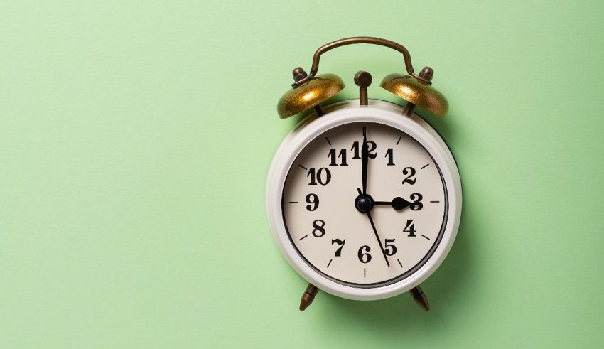 An alarm clock on a green background.