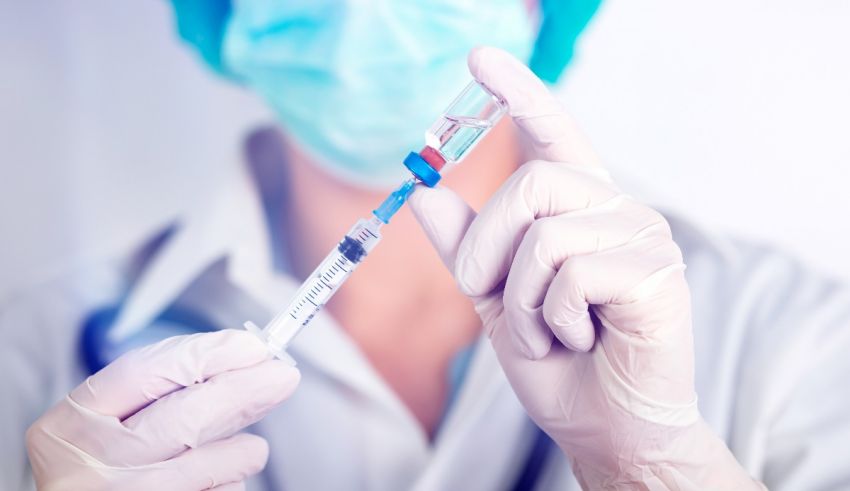 A doctor is holding a syringe in his hand.