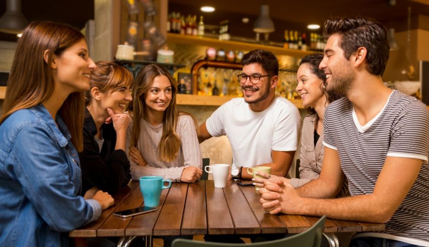 A group of friends sitting around a table in a cafe.