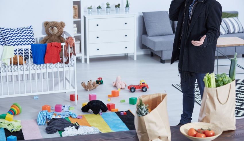 A man in a hoodie is standing in front of a baby's room.