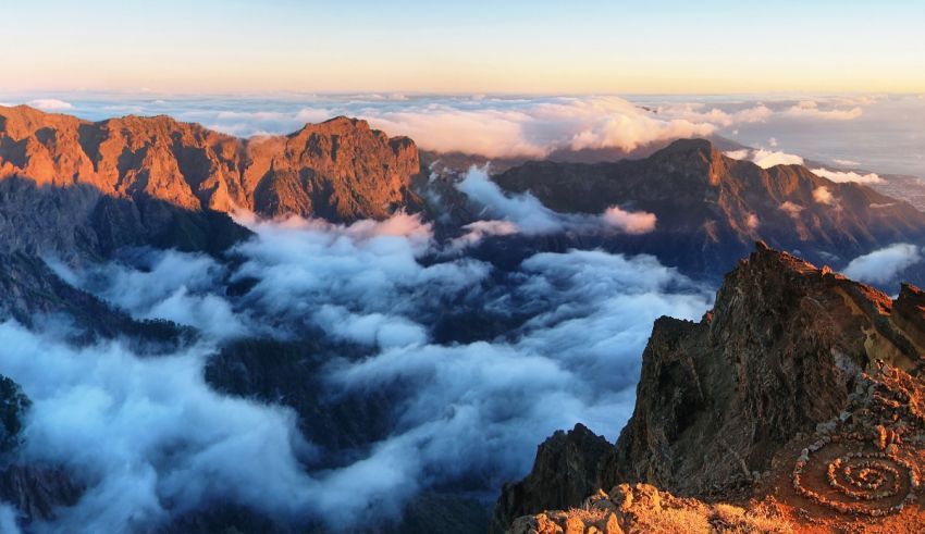 Sunrise over a mountain with clouds in the background.