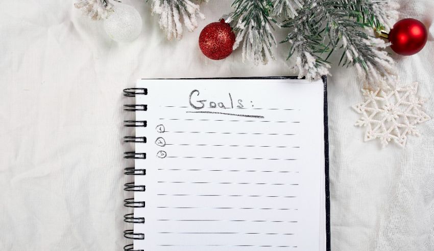 A notebook with the word goals on it next to christmas decorations.