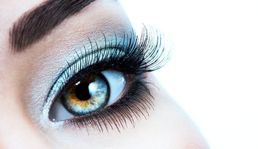 A close up of a woman's eye with blue eye makeup.