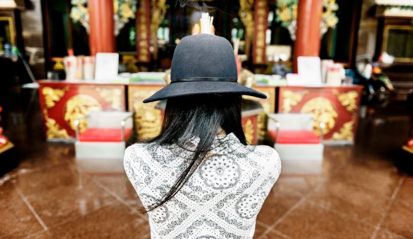 A woman wearing a black hat in a temple.