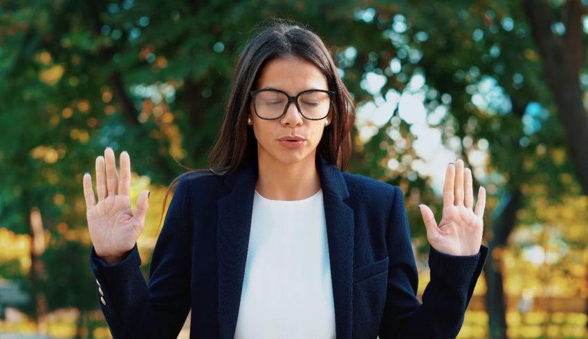 A woman in glasses is making a gesture with her hands.