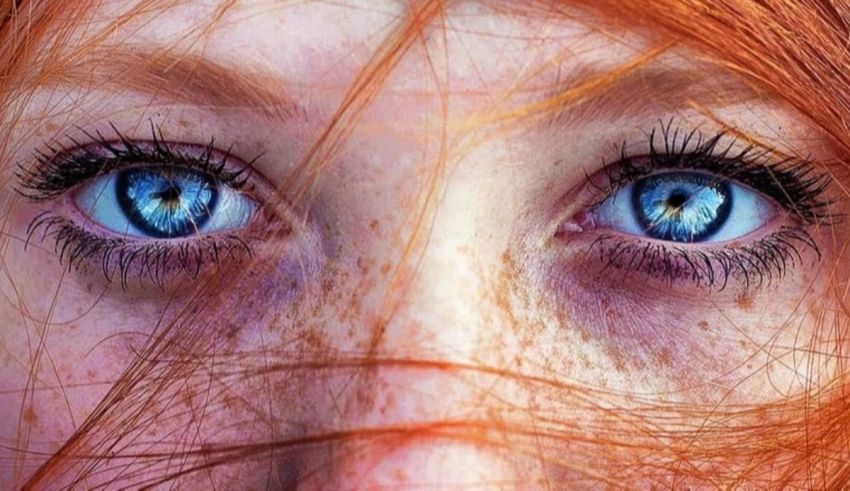 A close up of a woman with red hair and blue eyes.