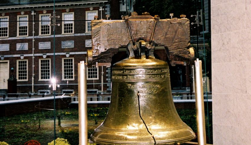 A large liberty bell in front of a building.